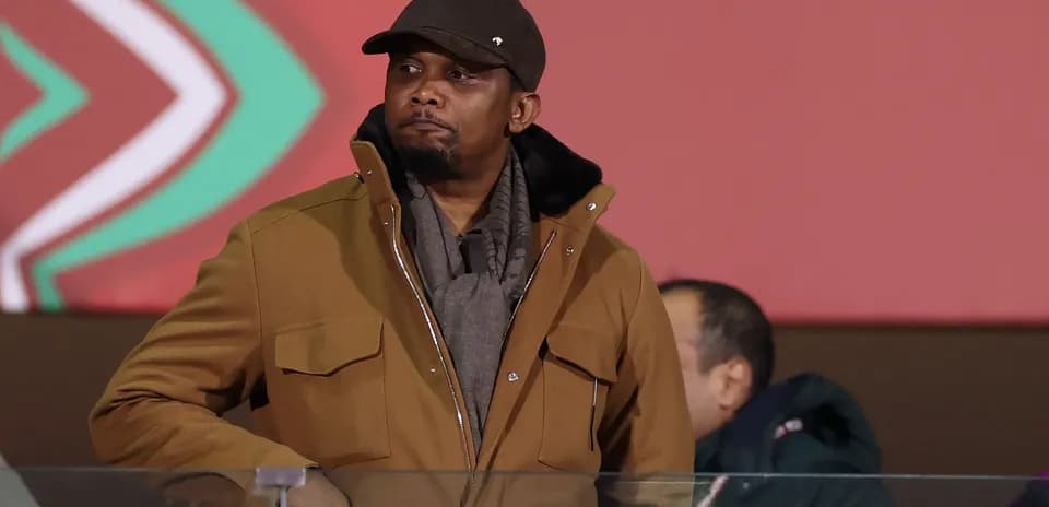 Man in brown jacket observing event from VIP area
