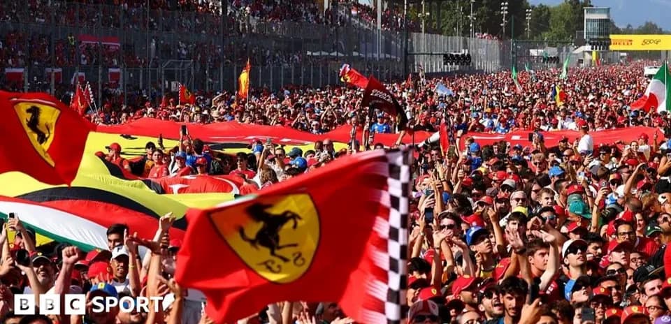 Large crowd of fans waving Ferrari flags at event