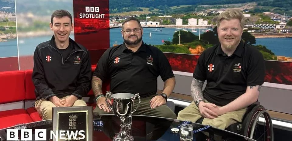 Three individuals with trophy on news studio set