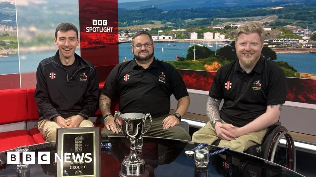 Three individuals with trophy on news studio set