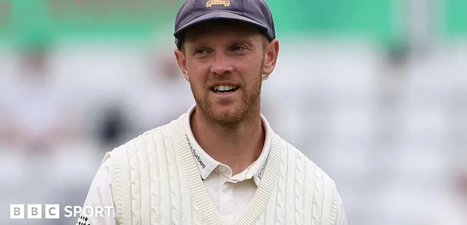 Cricketer wearing a white sweater on the field