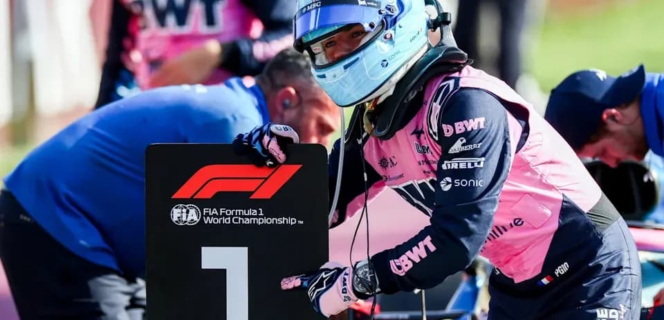 Driver holding '1' sign during Formula 1 event