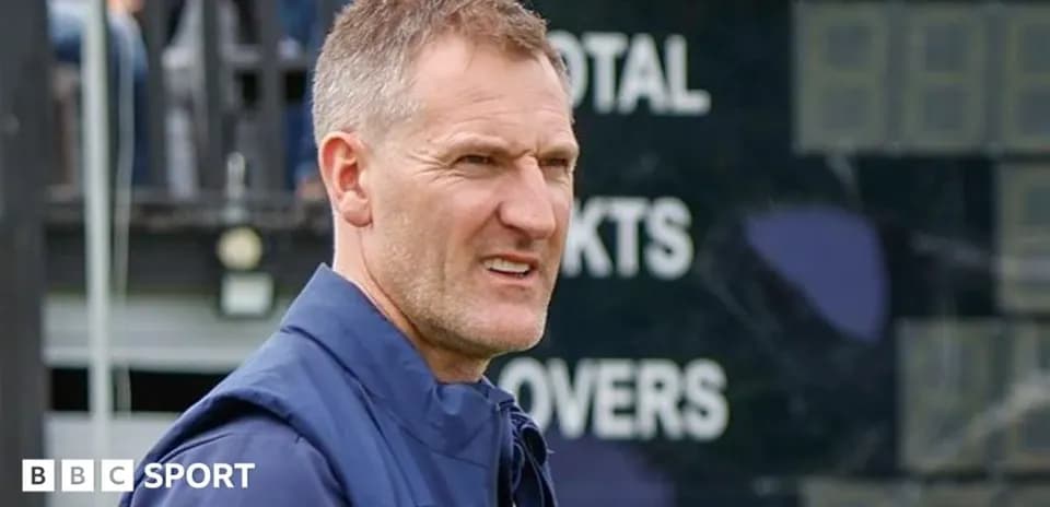 Coach observing the match near scoreboard