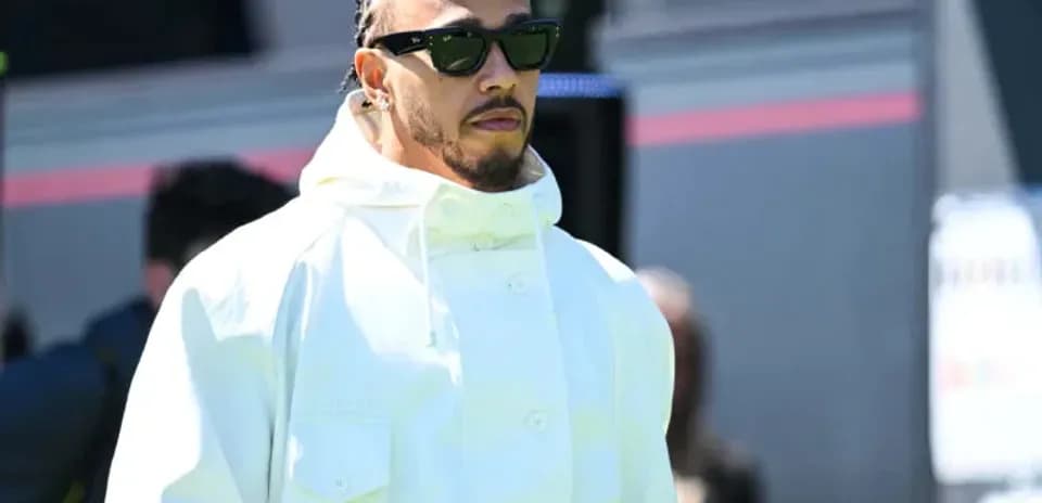 Driver wearing sunglasses and white jacket walking