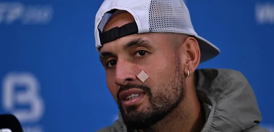 Player speaking at press conference with bandage on face