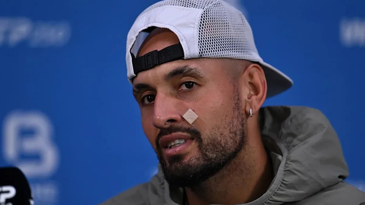 Player speaking at press conference with bandage on face