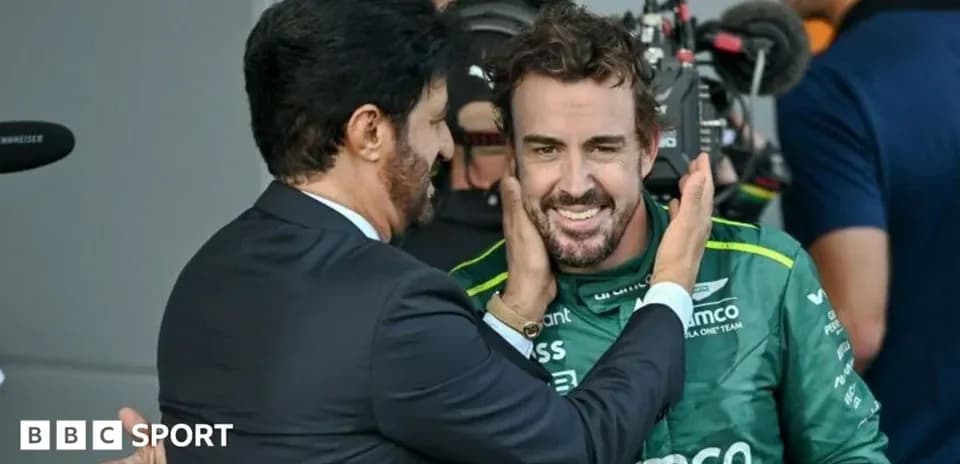 Two men interacting in a motorsport paddock