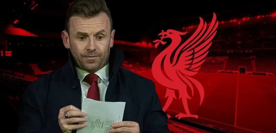 Man holding notes in front of Liverpool stadium