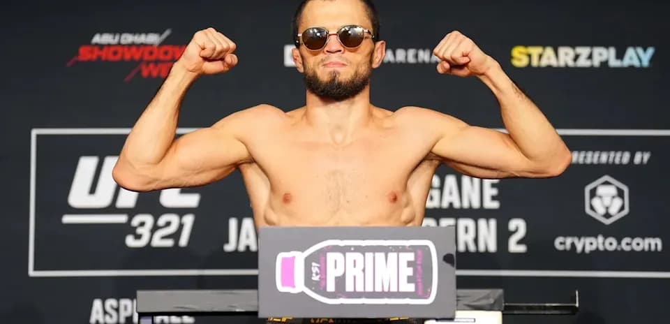 Fighter flexing muscles at weigh-in for UFC 321
