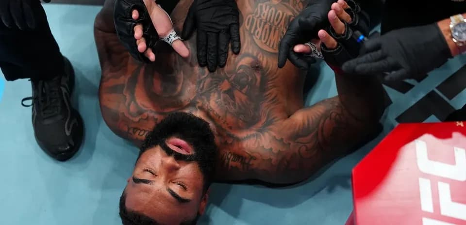 Fighter receiving medical attention on the mat