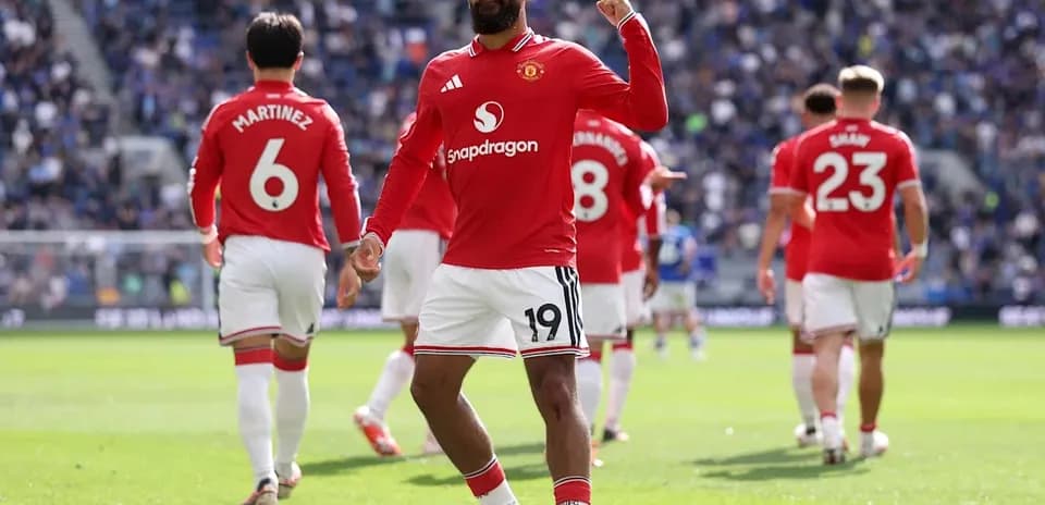 Player celebrating goal with teammates in stadium