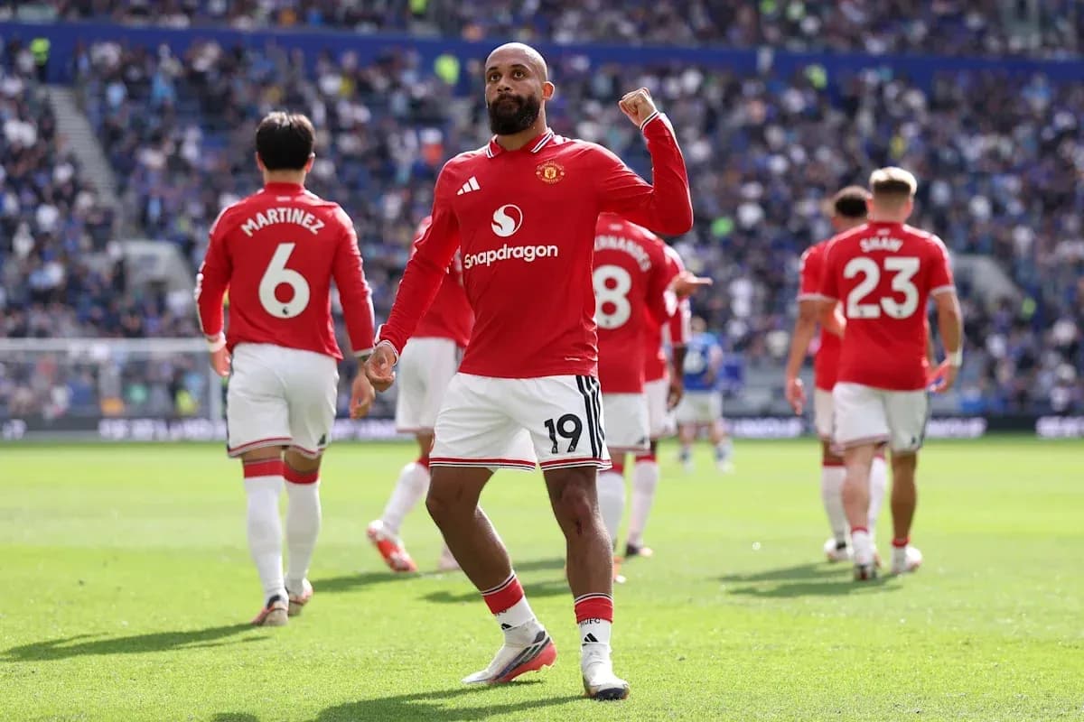 Player celebrating goal with teammates in stadium