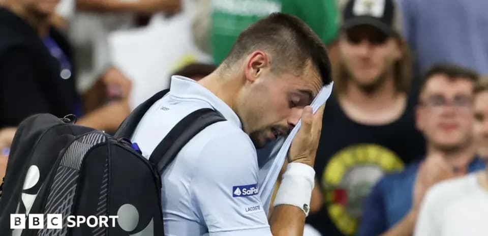 Tennis player wiping face during match in crowd