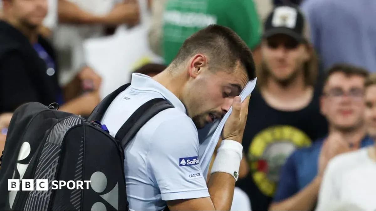 Tennis player wiping face during match in crowd