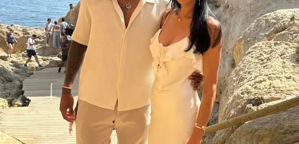 Couple posing by rocky seaside in summer attire