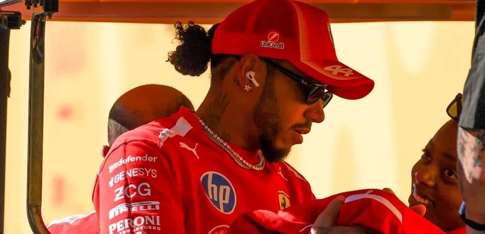 Driver interacting with fans in Ferrari team attire