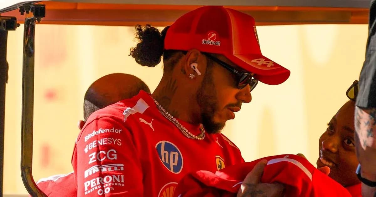 Driver interacting with fans in Ferrari team attire