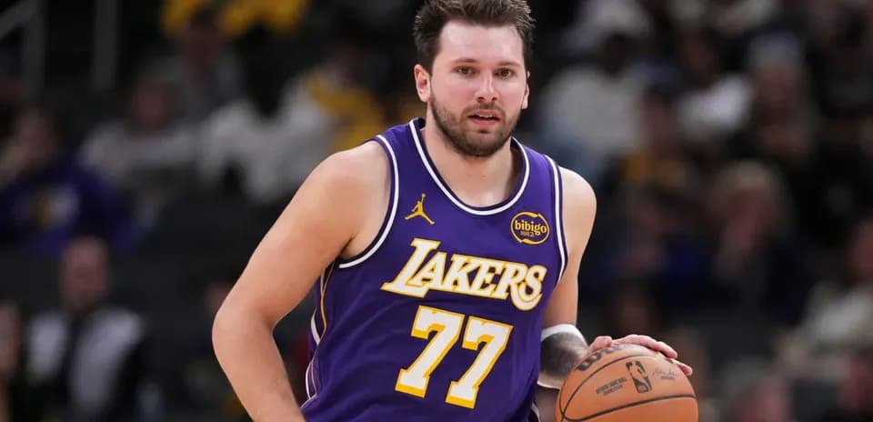 Player dribbling basketball during game in Lakers uniform