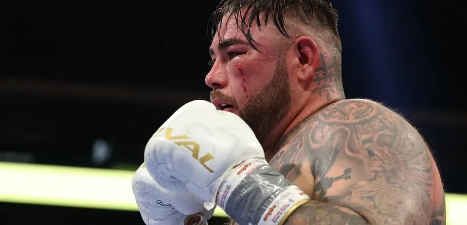 Boxer with tattoos and blood on face in ring