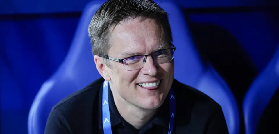 Man smiling while seated in stadium environment
