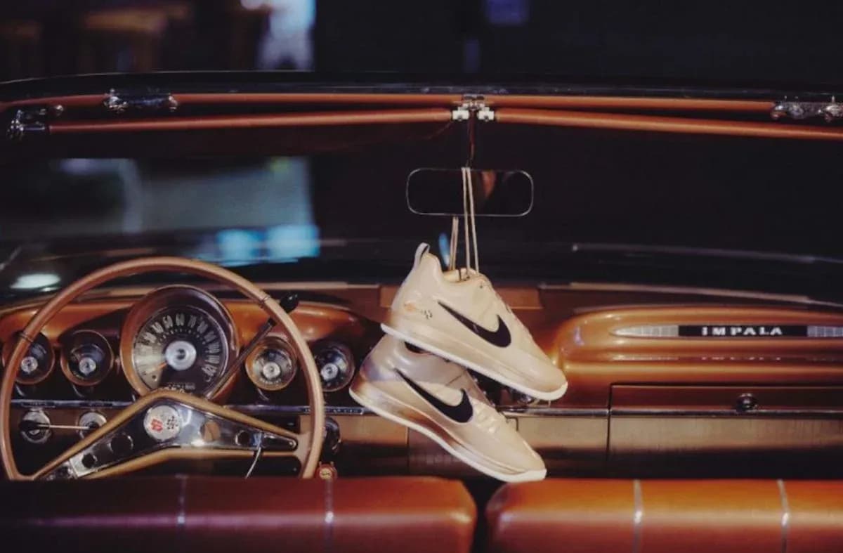 Nike sneakers hanging from classic car dashboard