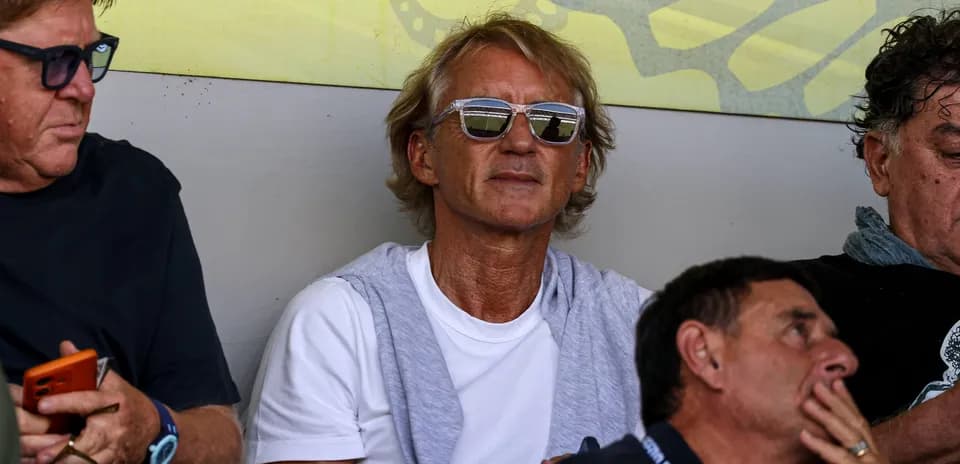 Man wearing sunglasses seated among others
