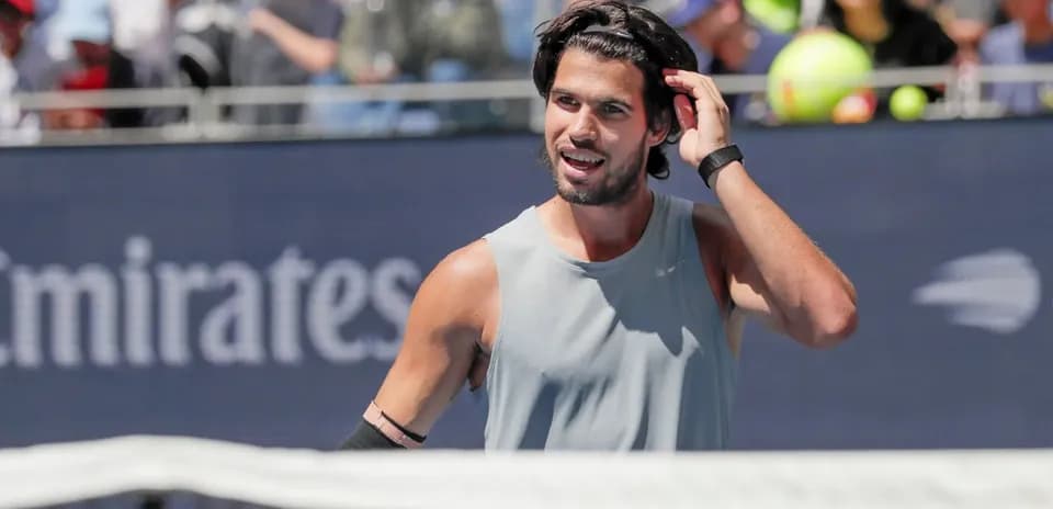 Tennis player adjusting his hair during match