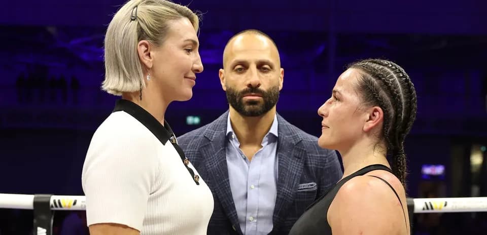 Two female fighters facing off with a referee present