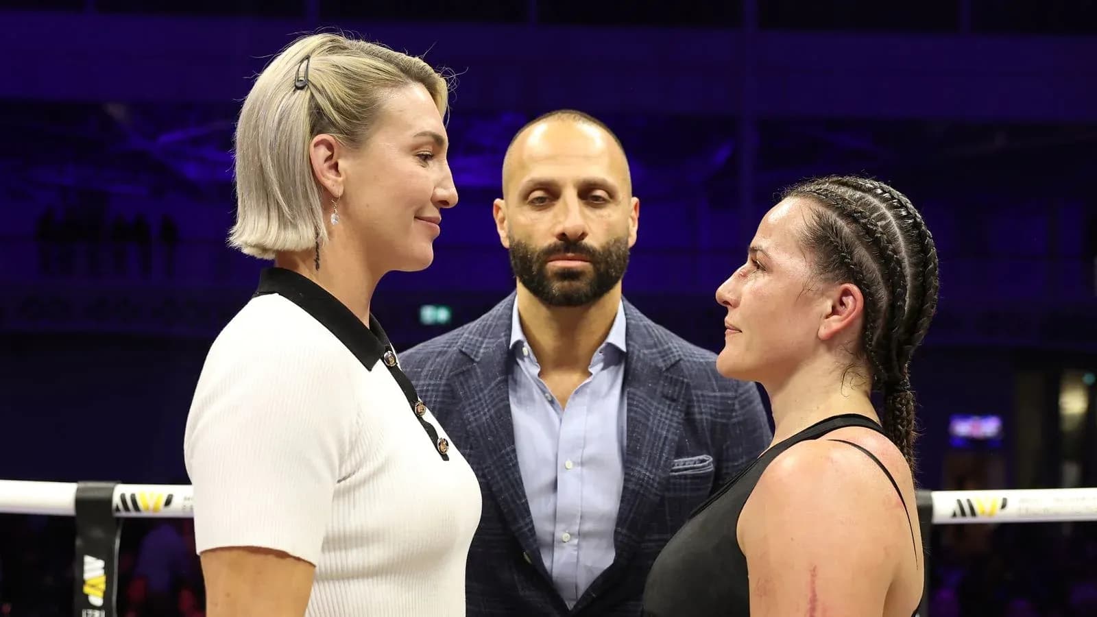 Two female fighters facing off with a referee present
