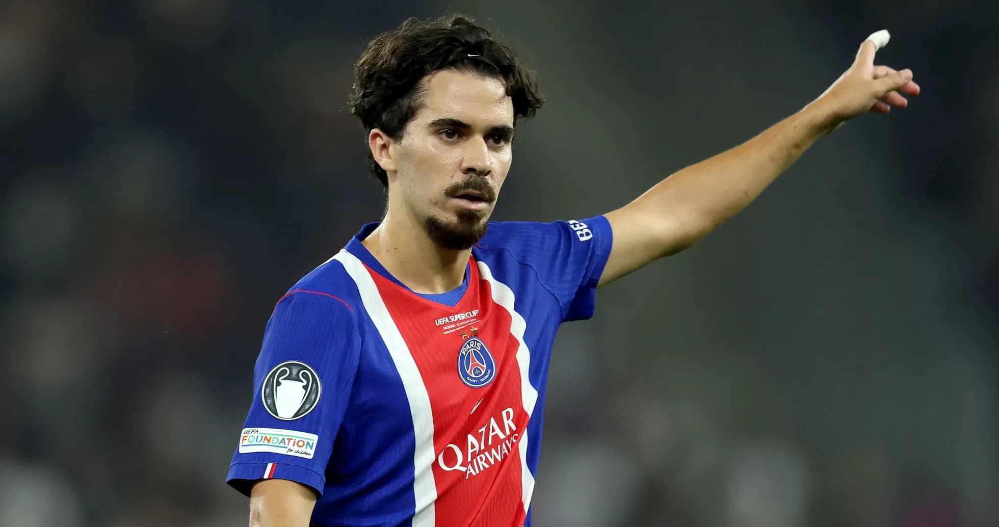Player gesturing during match wearing PSG jersey