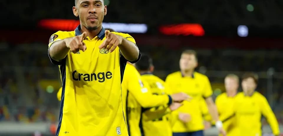 Player celebrating in yellow jersey with teammates