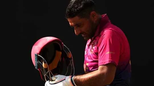 Cricketer adjusting helmet before batting
