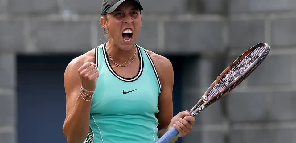 Tennis player celebrating with racket raised in victory