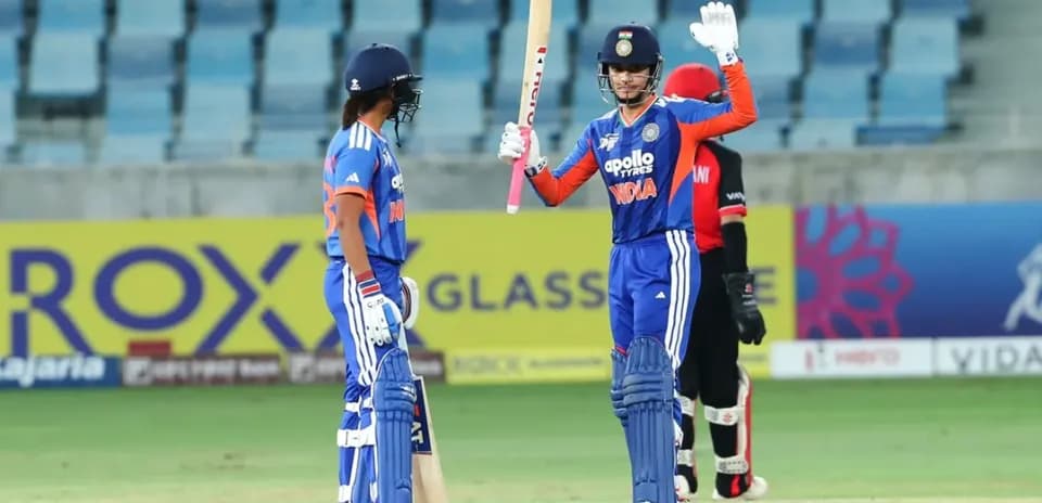 Batsman celebrating while teammate looks on during match