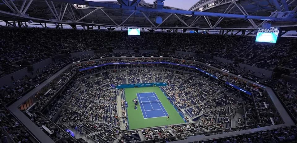 Crowd watching tennis match in stadium at dusk
