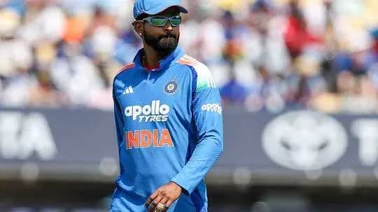 Cricketer in blue India jersey walking on field
