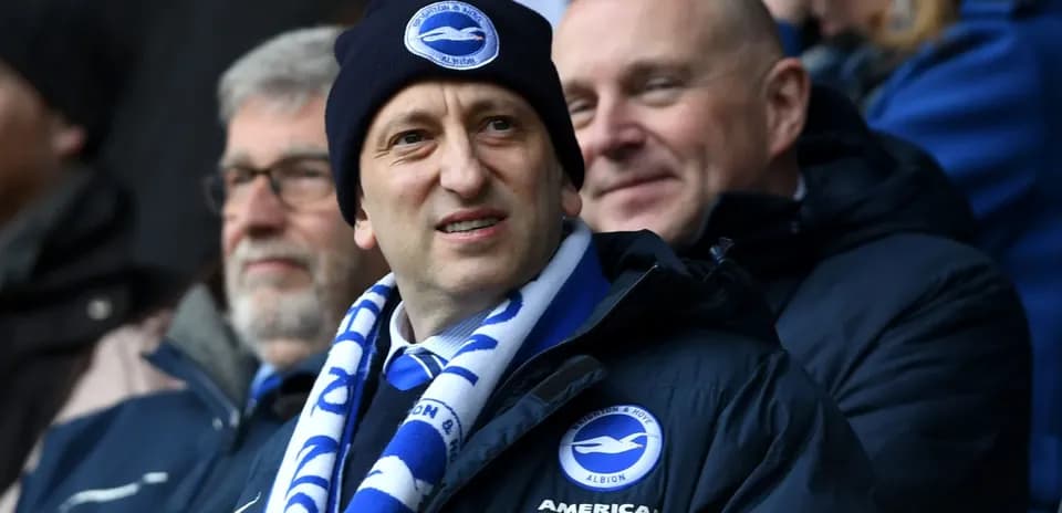 Man wearing Brighton scarf and beanie in stadium