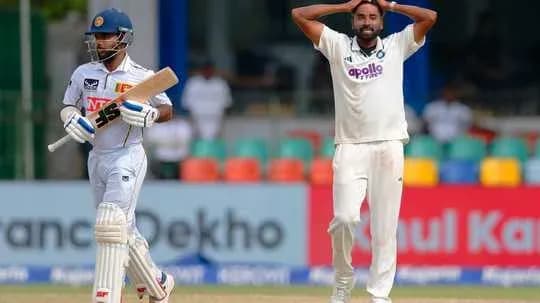 Bowler reacting after a delivery, batsman in background
