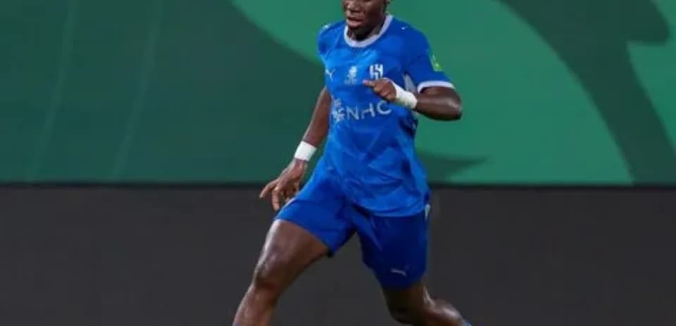 Player in blue jersey dribbling ball on field