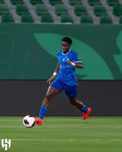 Player in blue jersey dribbling ball on field