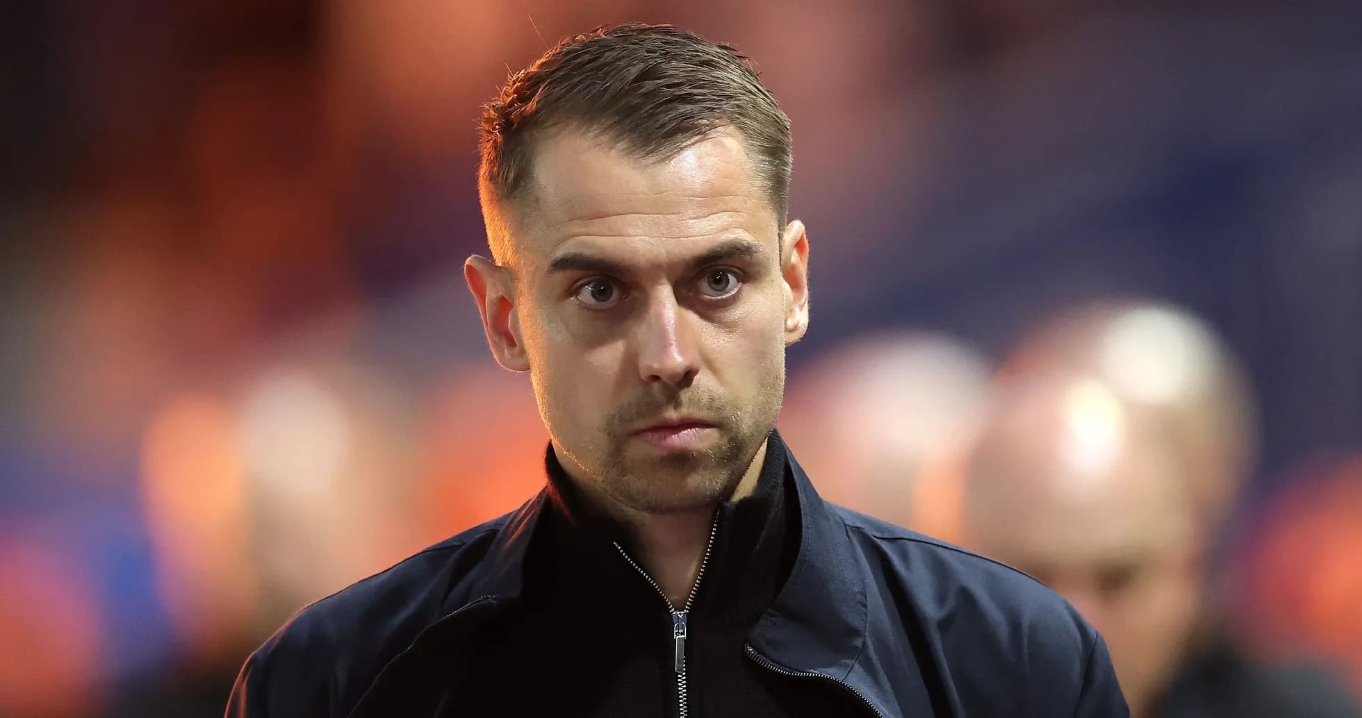 Man in a dark jacket with serious expression
