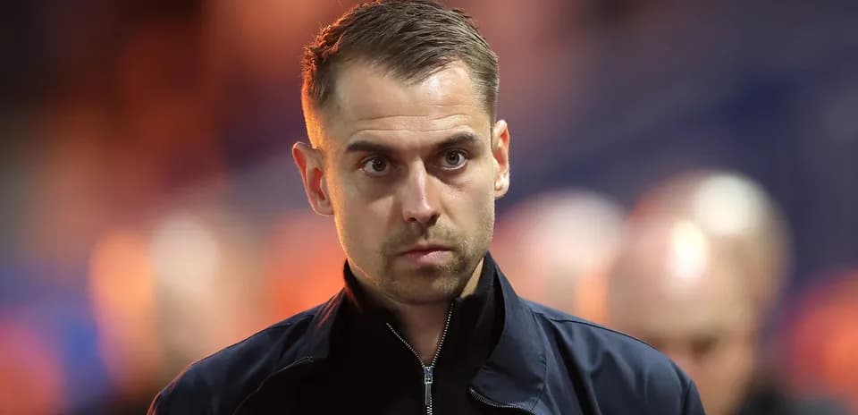 Man in a dark jacket with serious expression