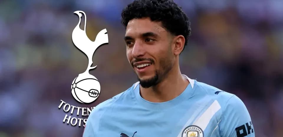 Player smiling in Manchester City jersey with Tottenham logo