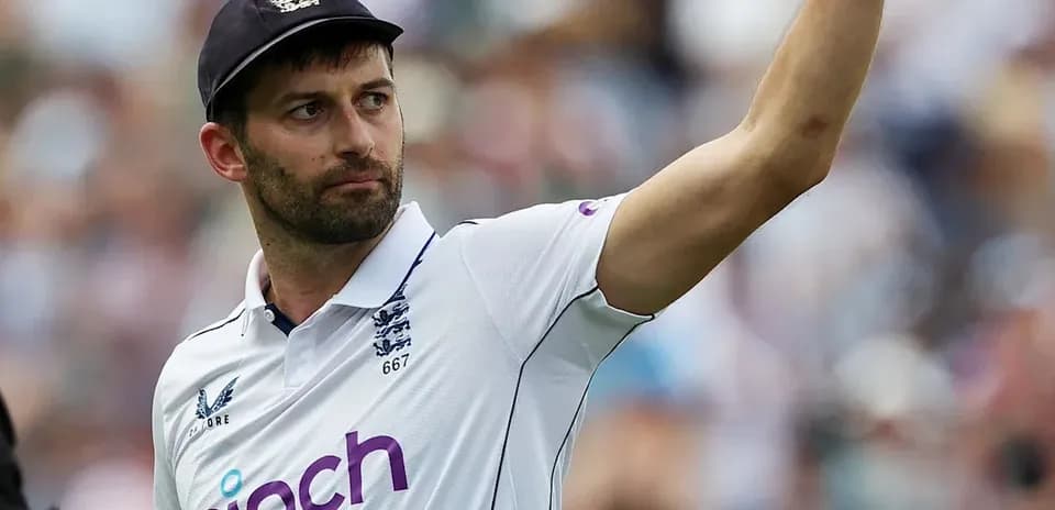 Cricketer gesturing during a match in white kit