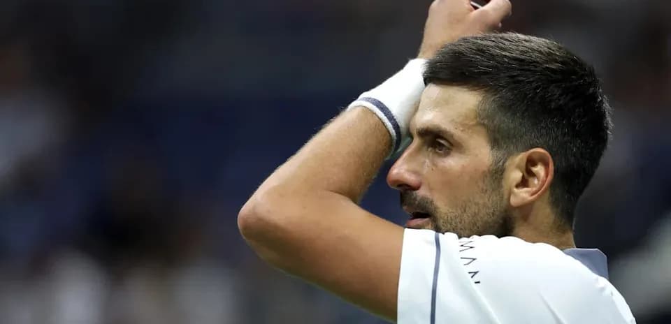 Tennis player adjusting his headband during match
