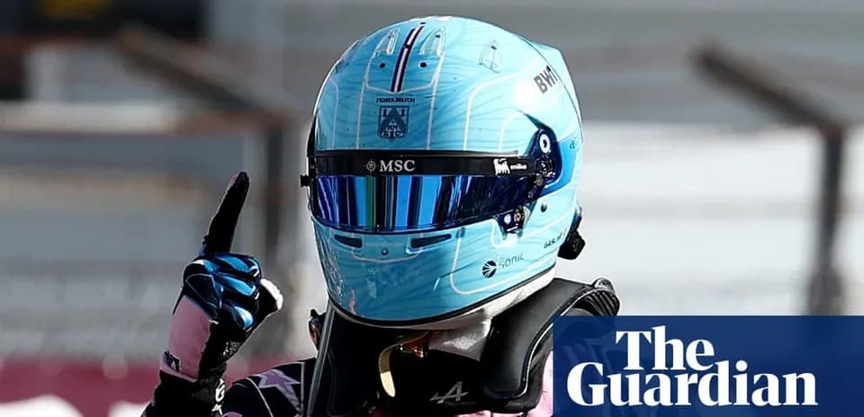 Racing driver celebrating with raised finger in helmet
