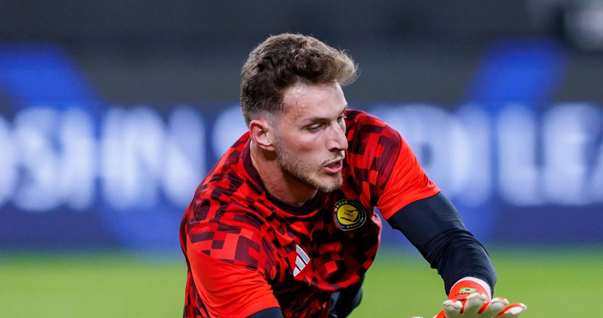 Goalkeeper in red uniform making a save