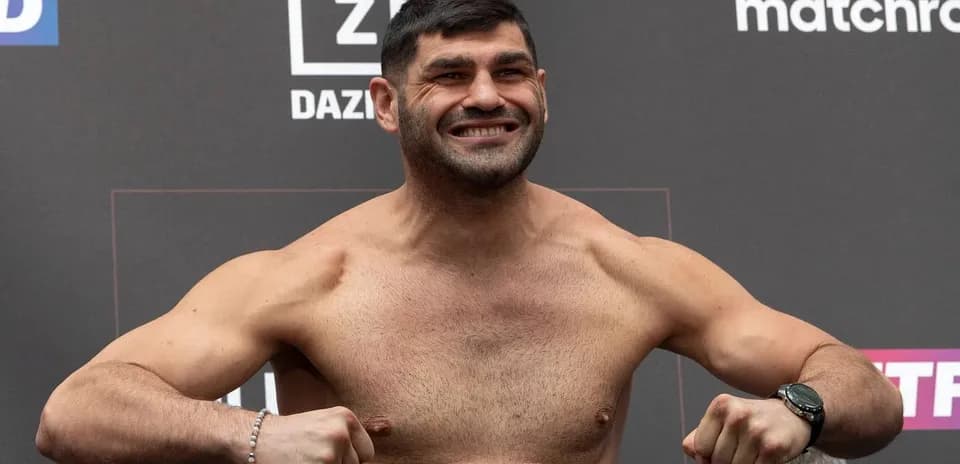 Fighter posing at weigh-in event with flexed muscles