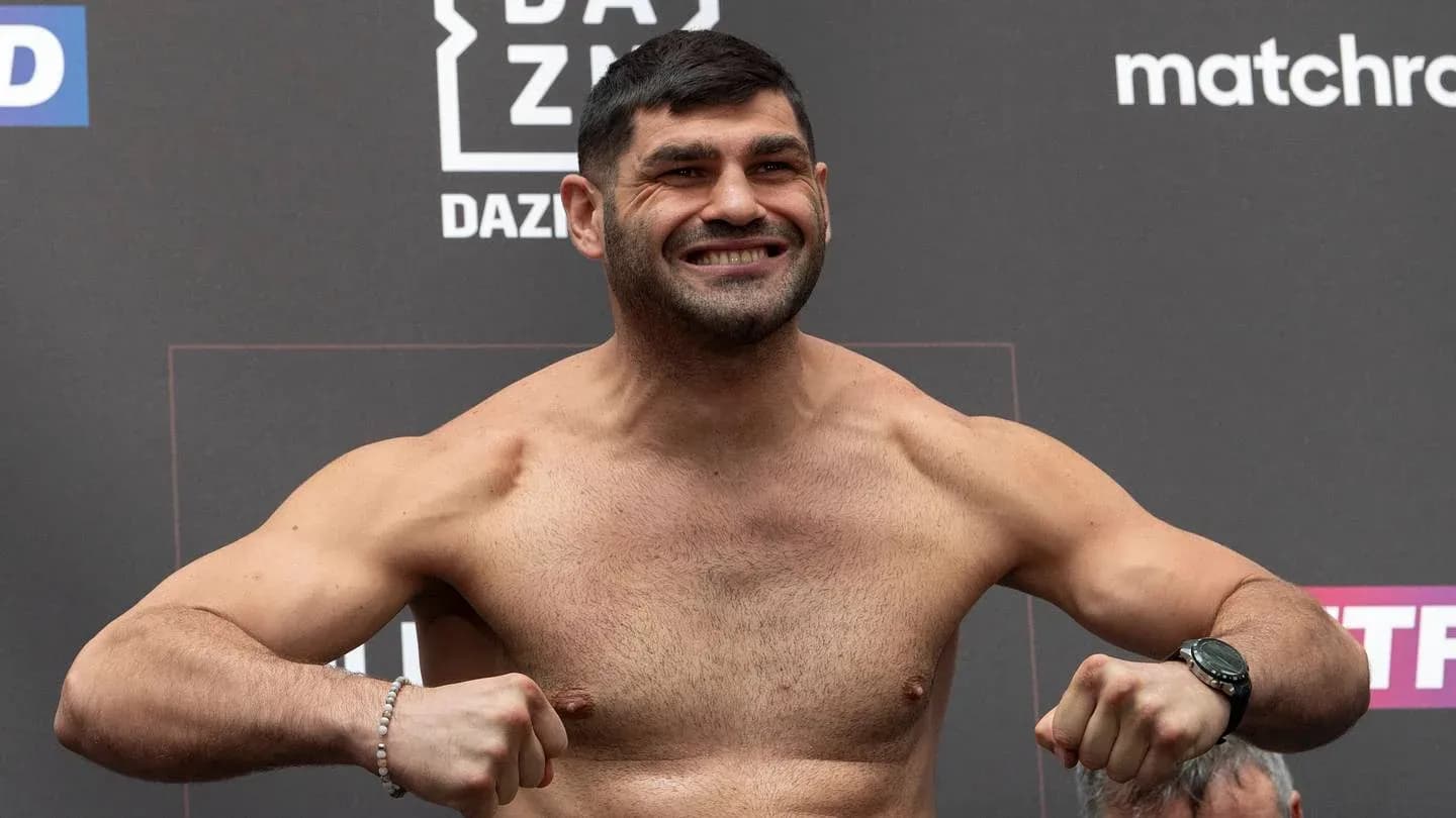 Fighter posing at weigh-in event with flexed muscles