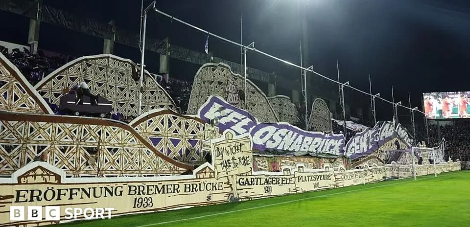 Fans displaying large banners in stadium stands
